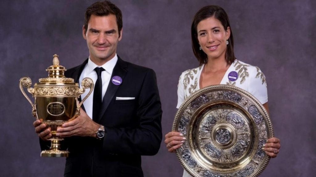 Garbine Muguruza and Roger Federer posing with their respective Wimbledon trophies in the Champions Dinner after the 2017 edition.