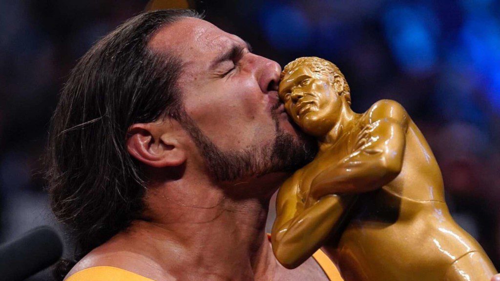 Madcap Moss kissing the Andre the Giant Battle royal trophy