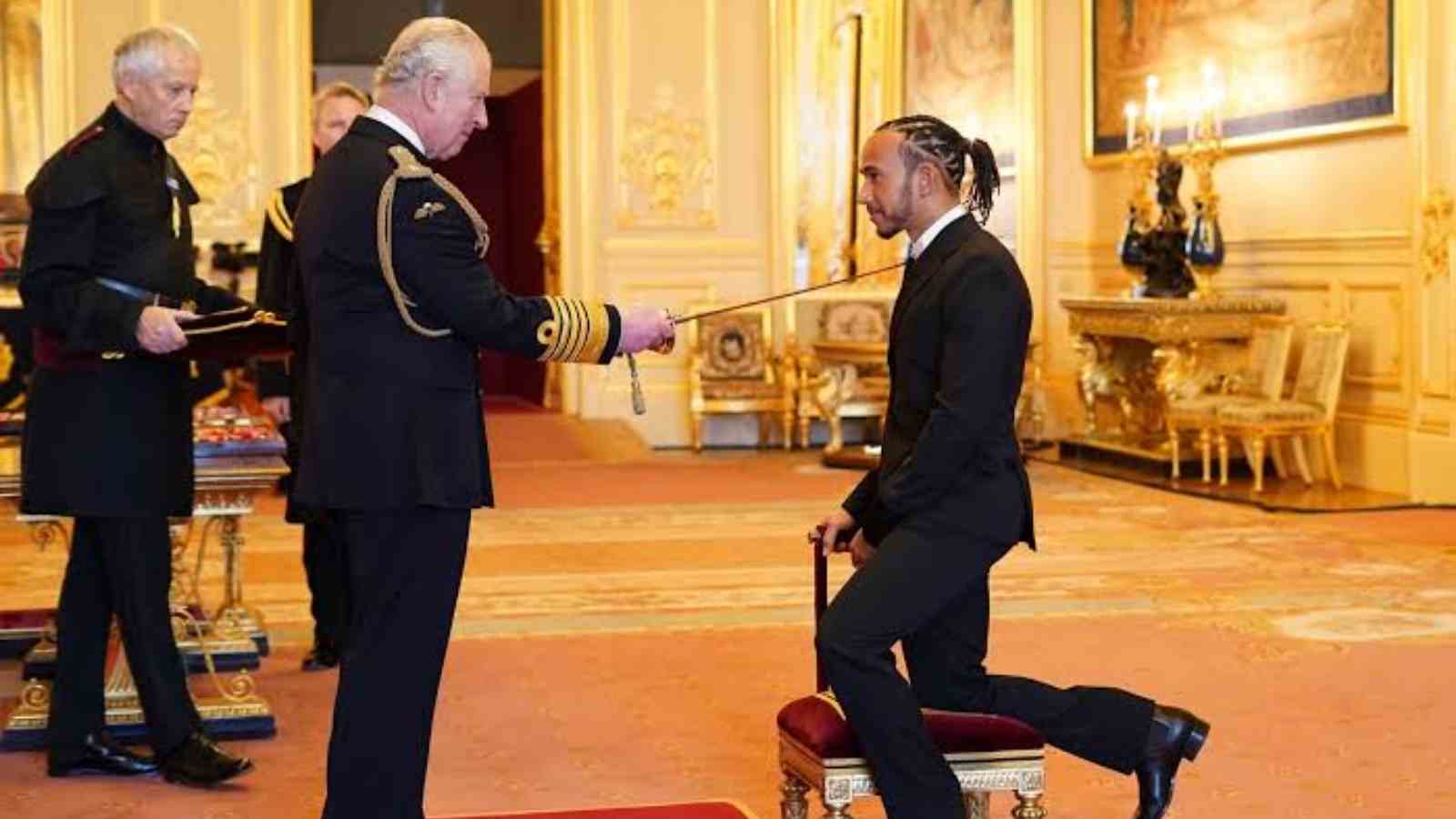 Lewis Hamilton being knighted by Prince Charles