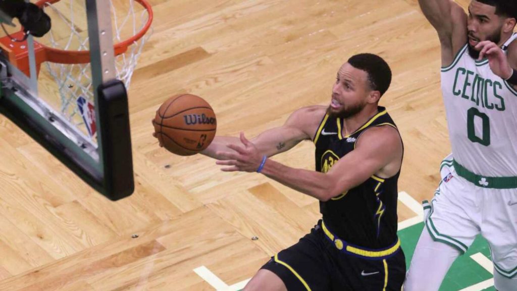 Stephen Curry goes past Jayson Tatum for a layup