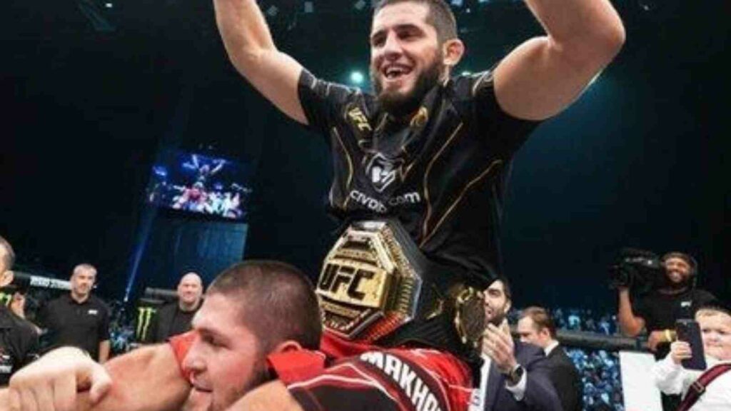 Khabib Nurmagomedov (bottom) hoists new lightweight champion Islam Makhachev (red shorts) on his shoulders