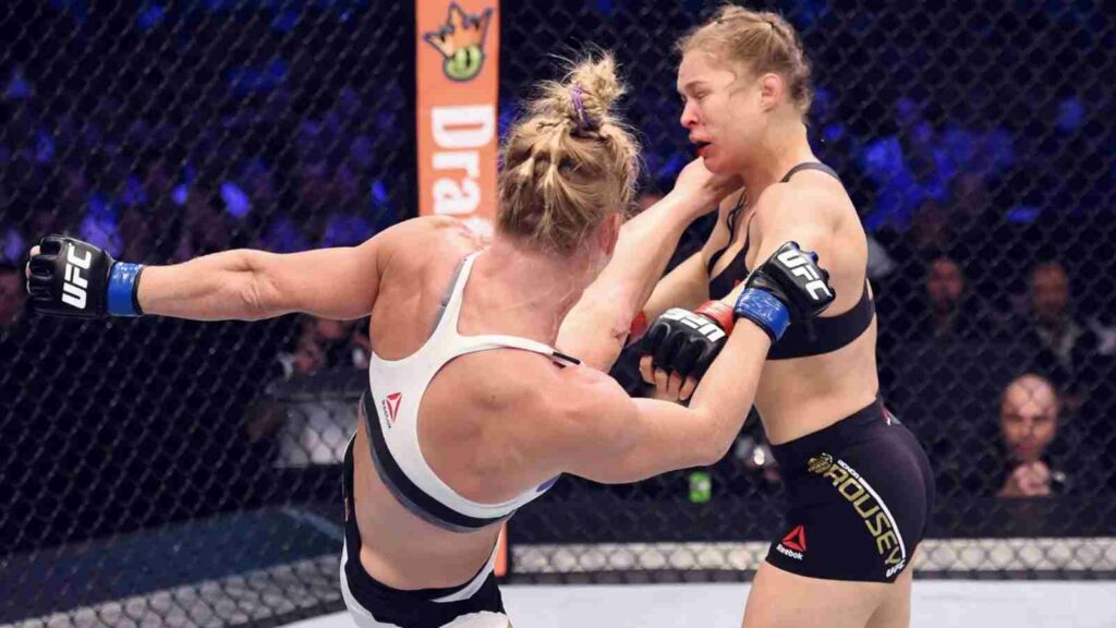 Holly Holm (in white) KO's Ronda Rousey (in black) to end her legendary run