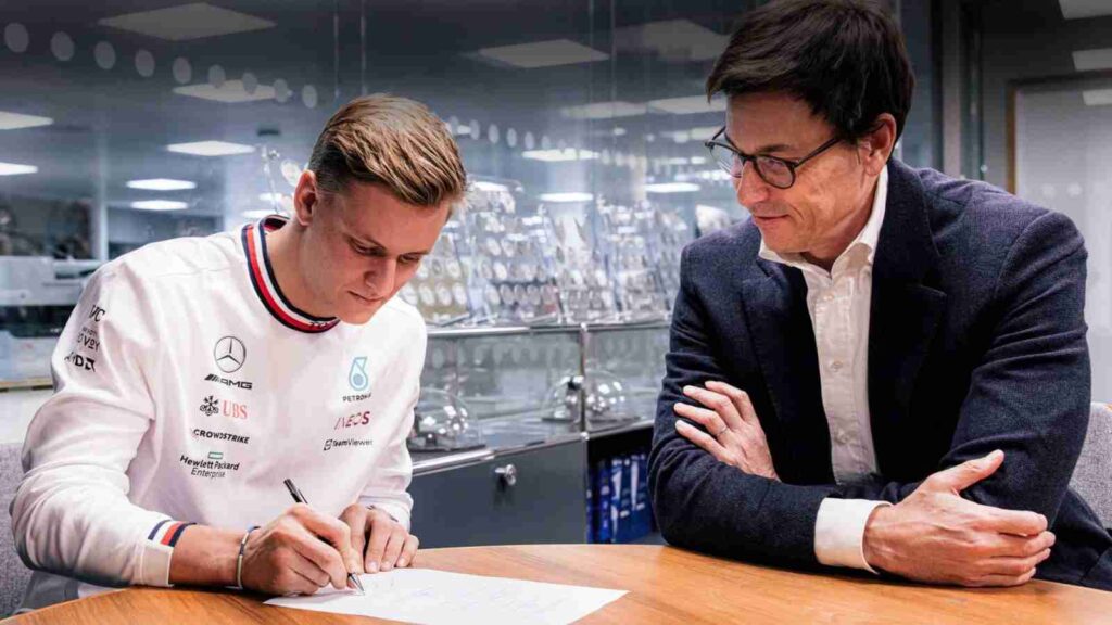 Mick Schumacher (L) signs his Mercedes contract with Toto Wolff (R) alongside him